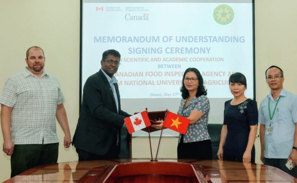 Prof. Dr. Nguyen Thi Lan and Dr. Aruna Ambagala exchange the Memorandum of Understanding