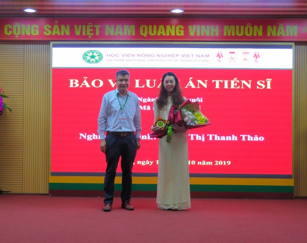 Đại diện Đảng ủy, Ban Giám đốc Học viện, GS.TS. Phạm Văn Cường tặng hoa chúc mừng nghiên cứu sinh